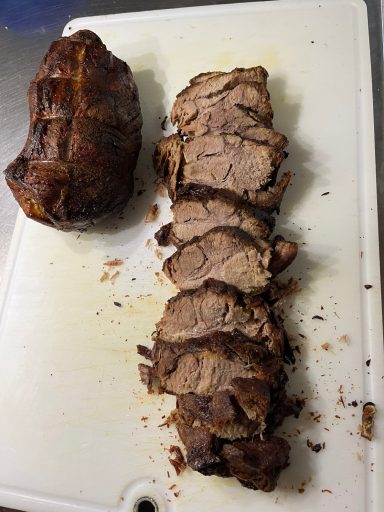 Gegrillter Schweinebraten aufgeschnitten auf einem Schneidebrett
