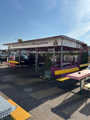 Biergarten mit Sitzmöglichkeiten unter dem Dach und unter Schirmen